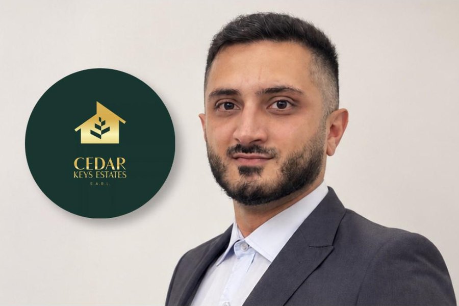Mustapha Fouladkar, founder of Cedar Keys Estates, beside the gold and dark green Cedar Keys Estates S.A.R.L. logo