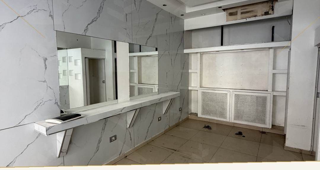 Fitted interior with a marble-effect feature wall, counter and full-height mirror, shop for rent in Sodeco, Achrafieh — Ref. 1199