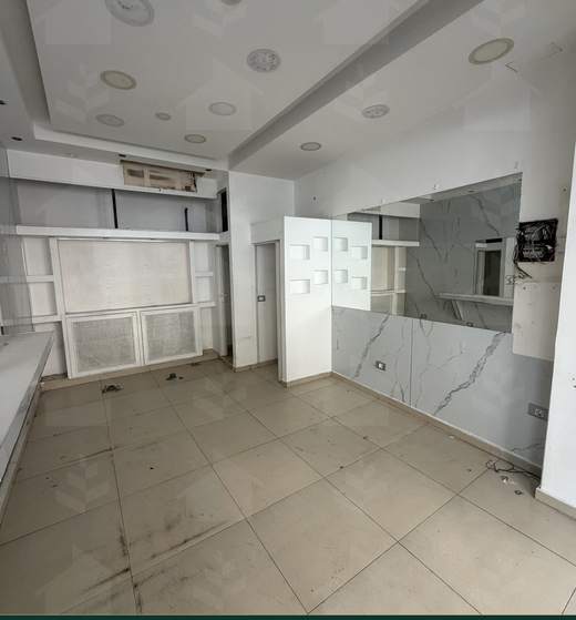 Shop interior from the other end, with built-in shelving and a recessed-spotlight ceiling, shop for rent in Sodeco, Achrafieh — Ref. 1199