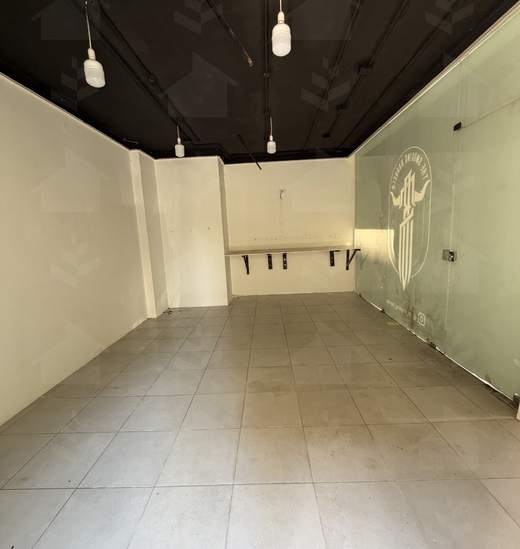 The shop along its full depth, tiled floor, glass partition and dark ceiling with pendant lights, Mar Mikhael, Beirut — Ref. 1193